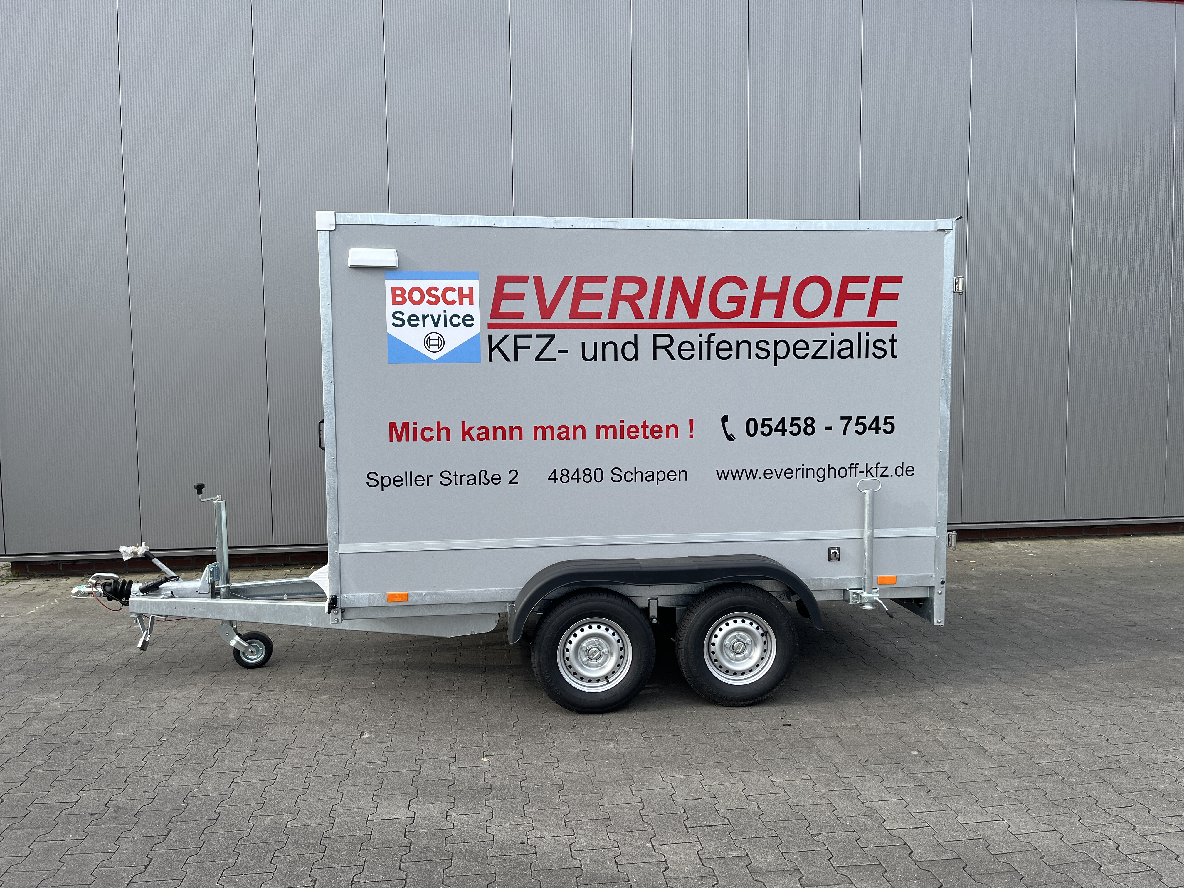 Grauer Kofferanhaenger von Everinghoff mit Bosch Service Werbung zum Mieten